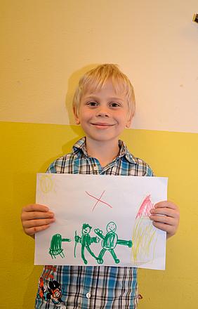 Kristian Specht, 6 Jahre alt aus Ingolstadt „Ich habe Menschen im Krieg gemalt und habe es durchgestrichen. Ich möchte nicht, dass Krieg ist, weil da auf die Menschen und Kinder geschossen wird. Außerdem habe ich Sonnenschein für alle gemalt.“ Foto: Kath. Kita IN gGmbH/Vogl