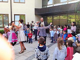 Mitreißende Klänge: Bürgermeister Tauer schwingt das Tanzbein zu den bayerischen Volksliedern, die die Kinder aus leibeskräften Singen. Foto: Kath. Kita IN gGmbH/Dunz