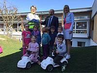 Kinder des kath. Kindergartens St. Rupert freuen sich über die neuen Rutscheautos.