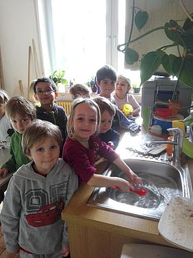 Ohne Strom funktioniert die Spülmaschine nicht: Die Kinder des Kindergartens St. Salvator spülen beim „Stromfasten“ ihre Teller selbst. Foto: Kath. Kita IN gGmbH/Faltermeier