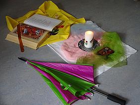 Bibel, Ikone, Kerzenflamme und Schirm: Zeichen für Gottes Liebe und Gegenwart. Foto: Kath. Kita IN gGmbH/Grosse